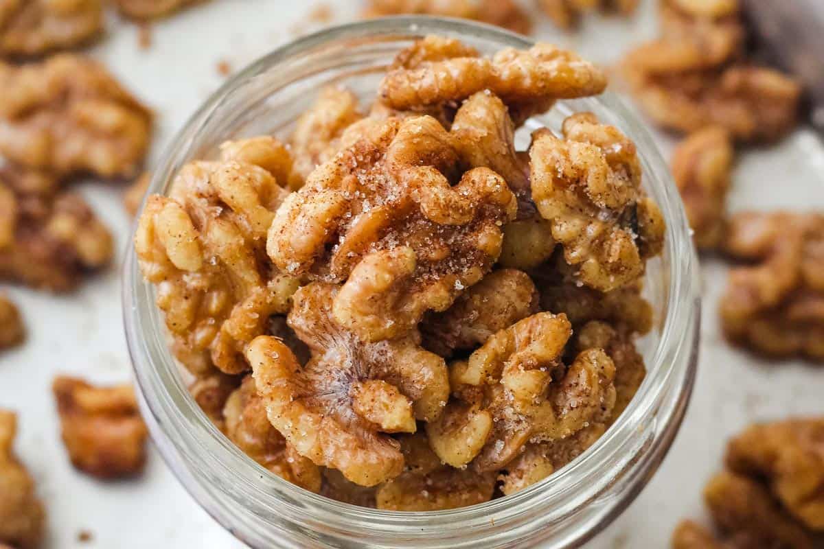 Close up of cinnamon sugar walnuts in a mason jar.