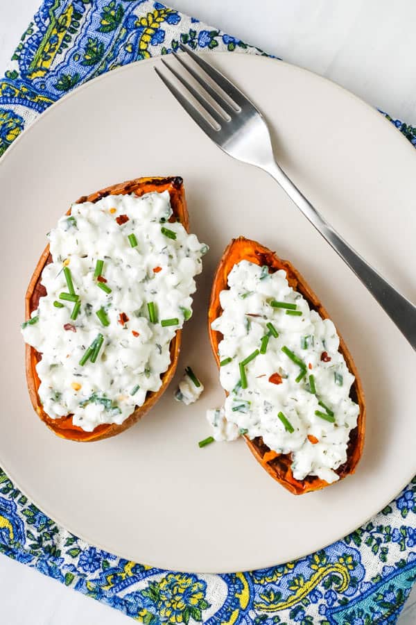 Plate with sweet potato halves topped with ranch-flavored cottage cheese and chives.