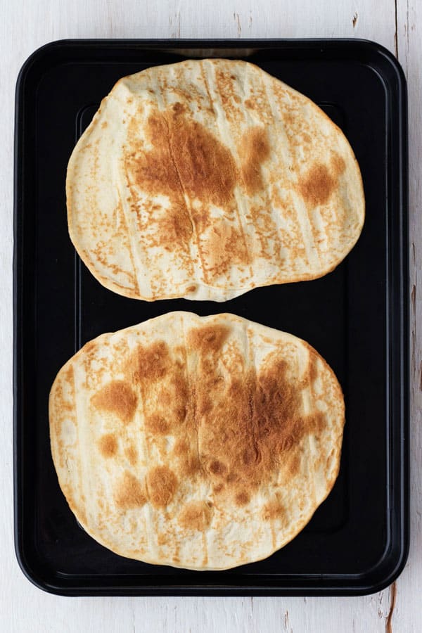 Pre-crisped tortillas on a pan.