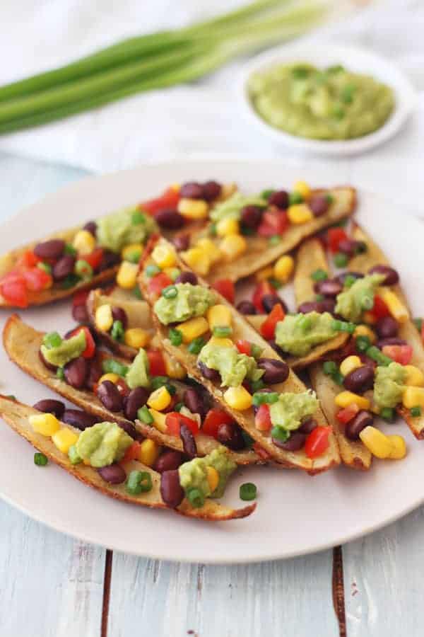 Potato skin strips on a plate with beans, salsa, and guacamole.