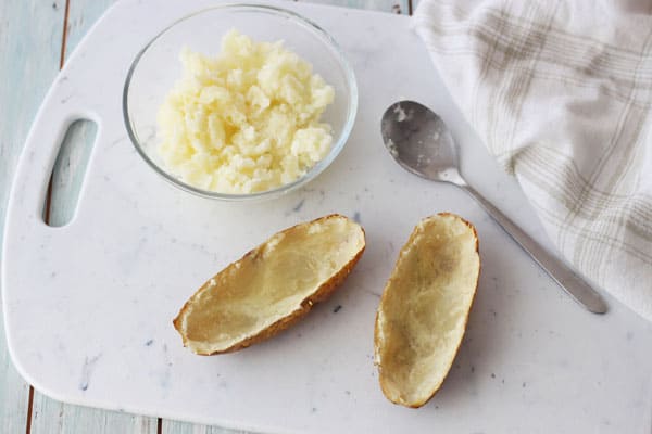 Toaster oven baked potato sliced open and scooped out to make shells.
