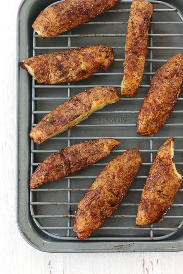 Crispy potato skins strips baked on a toaster oven rack and pan.