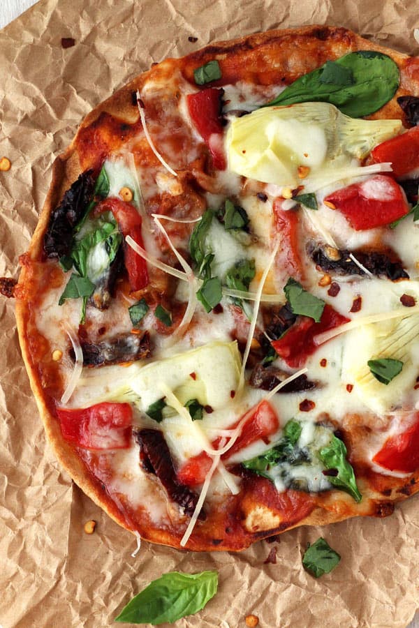 Closeup of melted cheese and vegetables on a baked tortilla.