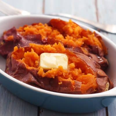 Baked sweet potato with butter in a baking dish.