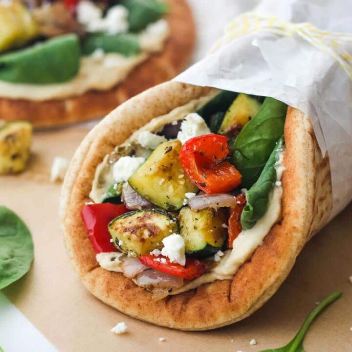 Closeup of wrapped pita sandwich with roasted vegetables.