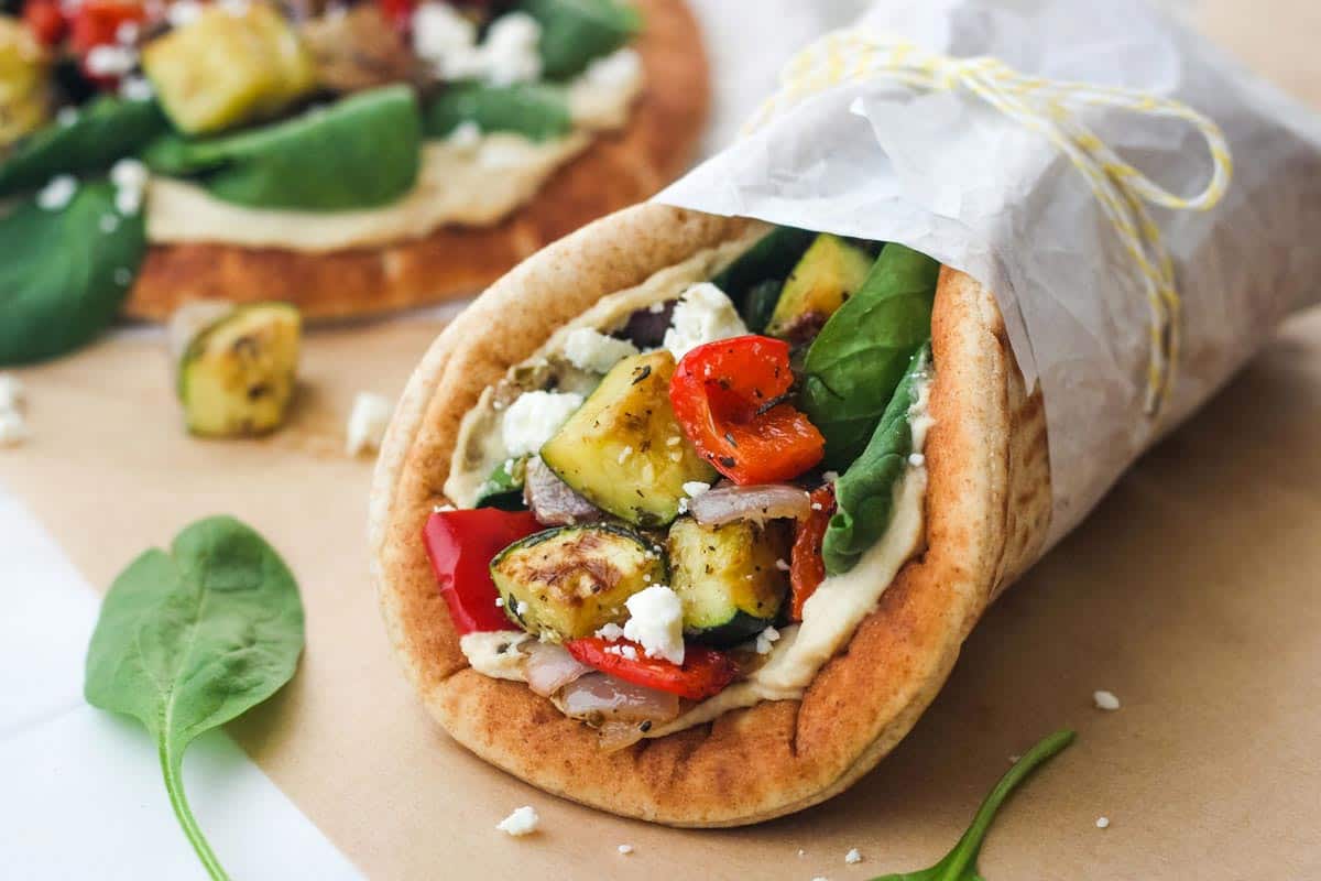 Closeup of wrapped pita sandwich with roasted vegetables.