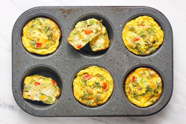 Overhead view of baked frittatas in a muffin tin.