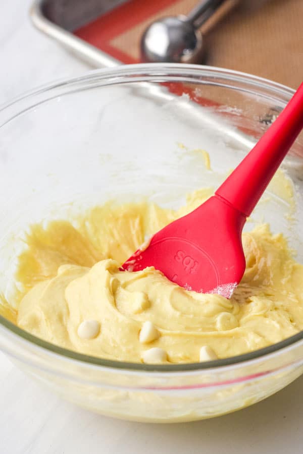 Sticky yellow cookie dough in a glass bowl.