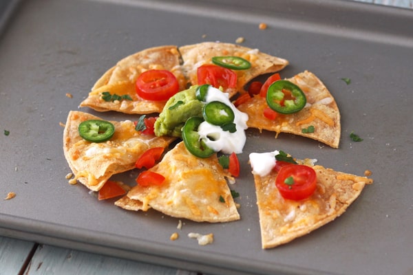 Cheesy baked chips with Greek yogurt and jalapeno slices.