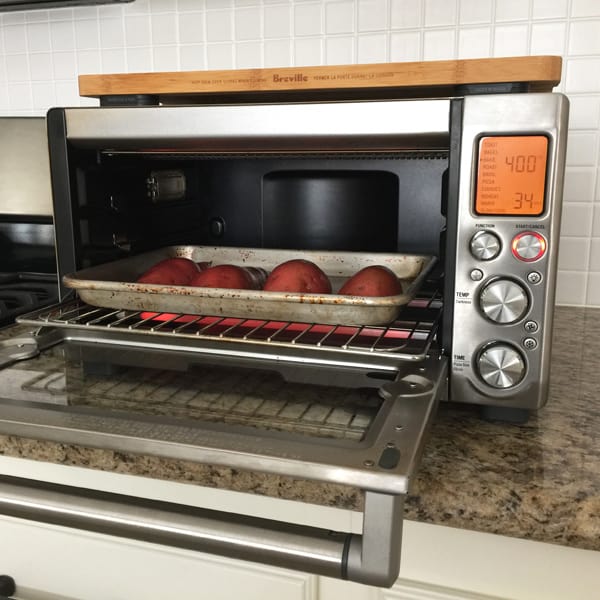 A quarter sheet pan of sweet potatoes inside a Breville Smart Oven Pro.