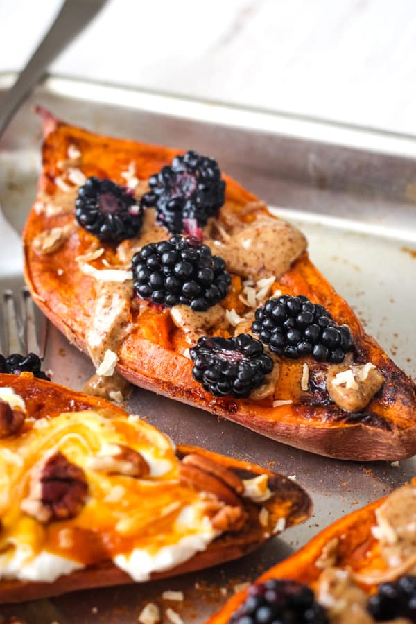 Quick Baked Sweet Potatoes - Top with almond butter and berries for a filling breakfast! Baked sweet potato halves topped with almond butter and blackberries.