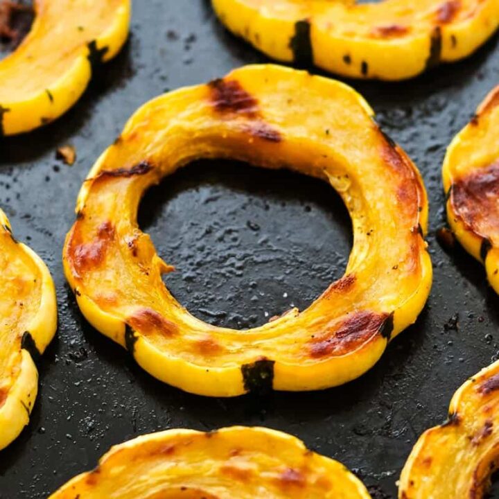 Closeup of roasted squash rings on a baking pan.