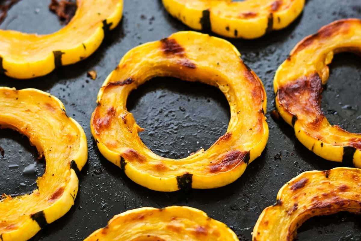 Closeup of roasted squash rings on a baking pan.
