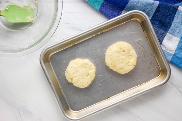Biscuit dough patted into two small rounds on an small sheet pan.