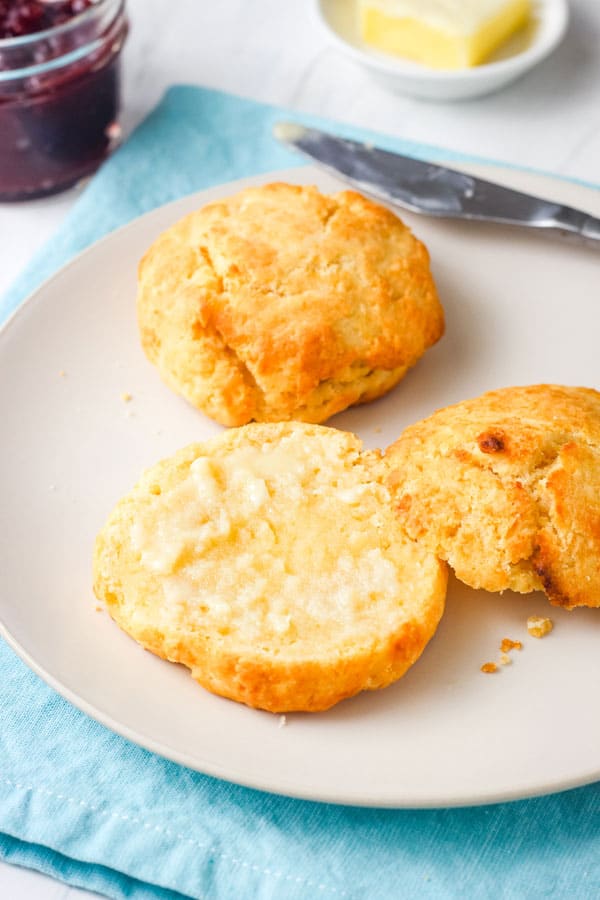 Plate with a biscuit split and buttered.
