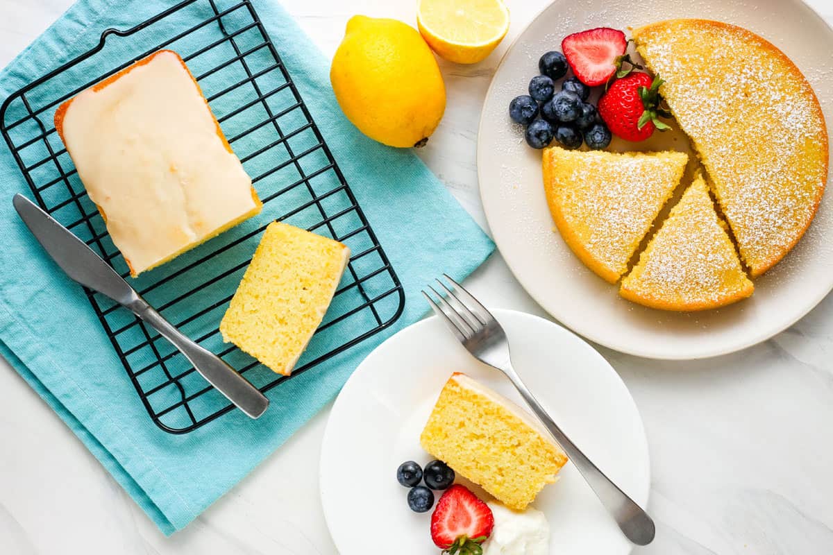 Overhead view of small cake on plate with berries and mini loaf sliced into pieces.
