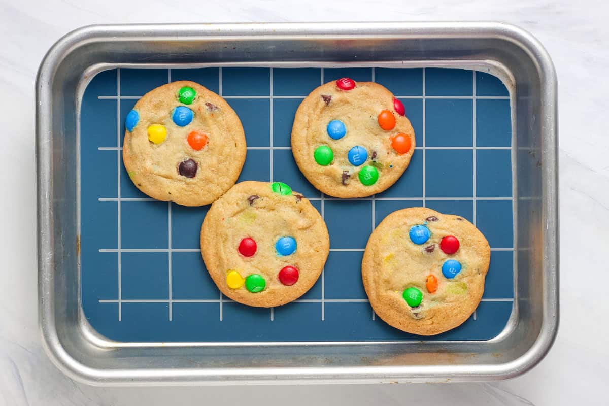 Overhead view of baked chocolate chip cookies on a lined eighth sheet pan.