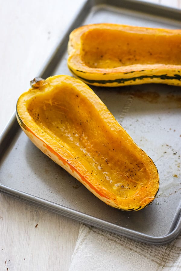 Empty roasted delicata squash boats on a toaster oven baking sheet.