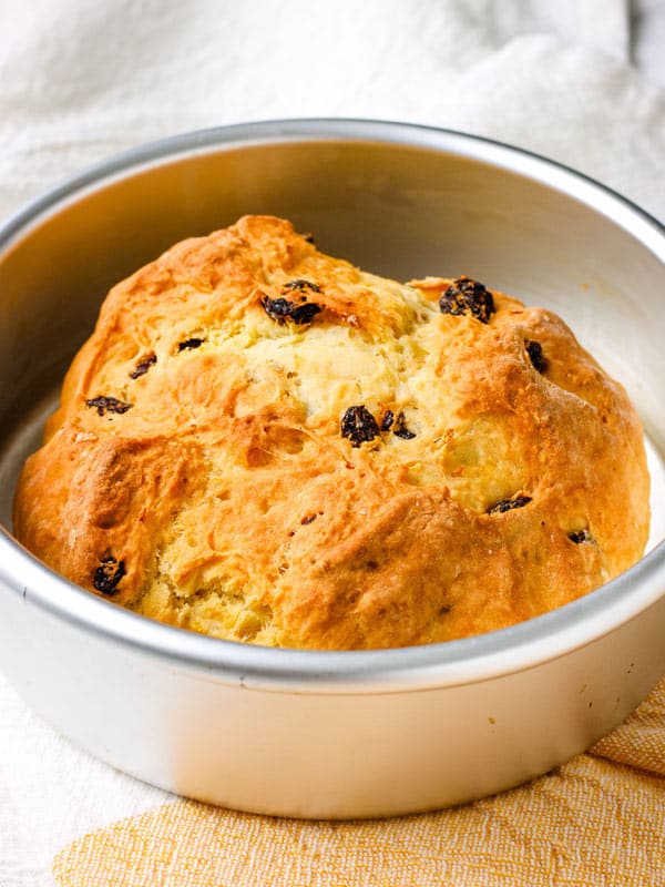 Golden-baked bread with raisins in a 6-inch cake pan.