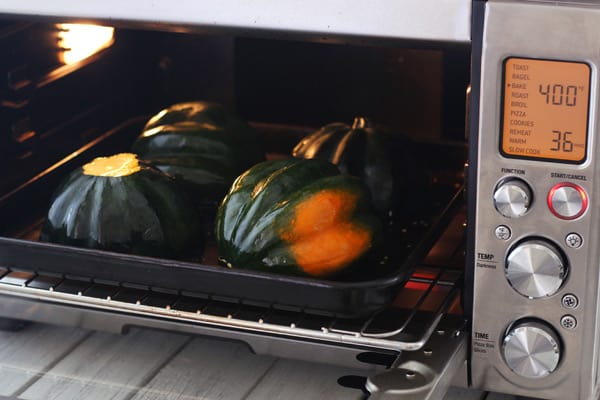 acorn squash halves on a baking pan in the toaster oven