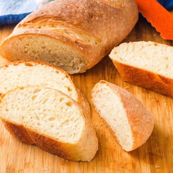 Cutting board with slices of golden baked bread and a knife.