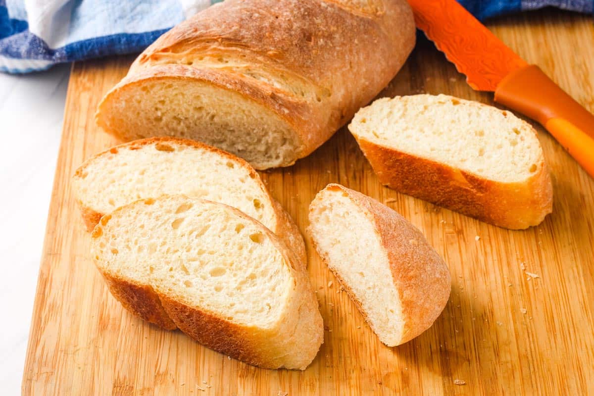 Cutting board with slices of golden baked bread and a knife.