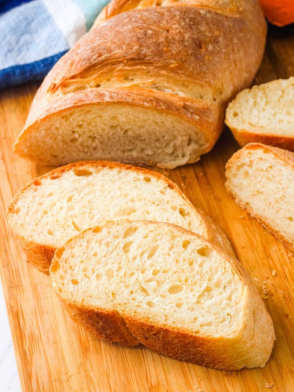 Cutting board with a small bread loaf sliced into pieces.