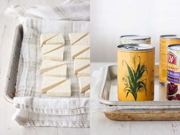 Tofu on a towel lined pan and pressed with canned vegetables.