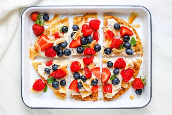 Breakfast fruit pizza cut into slices.