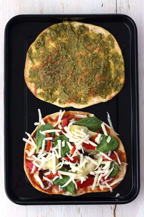 Tortillas with sauce and toppings on a pan.