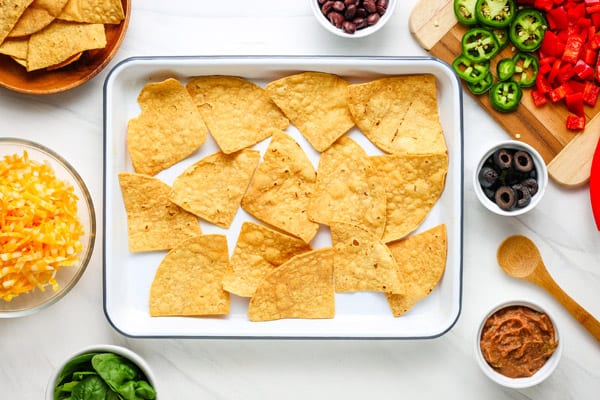 Corn tortilla chips on baking sheet.