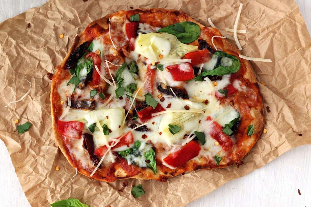 Crispy vegetable tortilla pizza on a table.